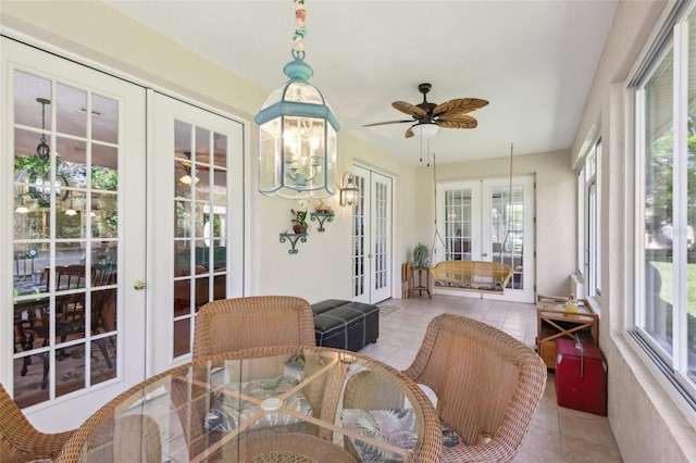 sunroom featuring ceiling fan with notable chandelier and french doors