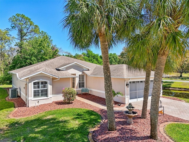 ranch-style home with roof with shingles, driveway, stucco siding, a garage, and central air condition unit