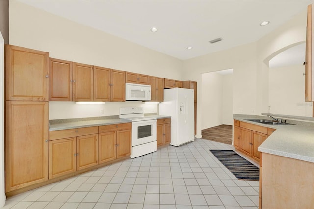 kitchen featuring visible vents, light countertops, light tile patterned flooring, white appliances, and a sink