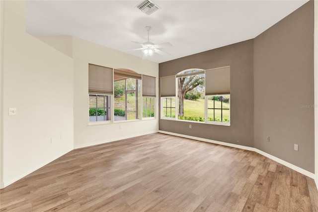 empty room with light wood-type flooring, visible vents, and a wealth of natural light