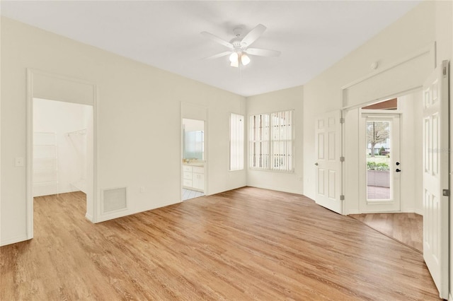 unfurnished room with light wood-style floors, visible vents, and ceiling fan