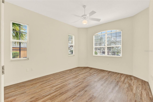 empty room with wood finished floors, baseboards, and ceiling fan