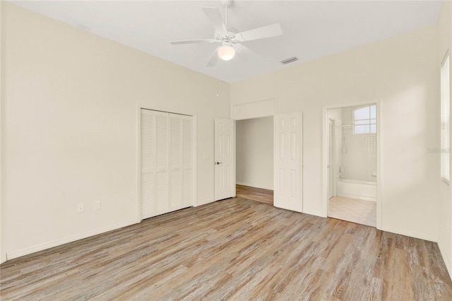 unfurnished bedroom featuring a closet, visible vents, baseboards, and wood finished floors