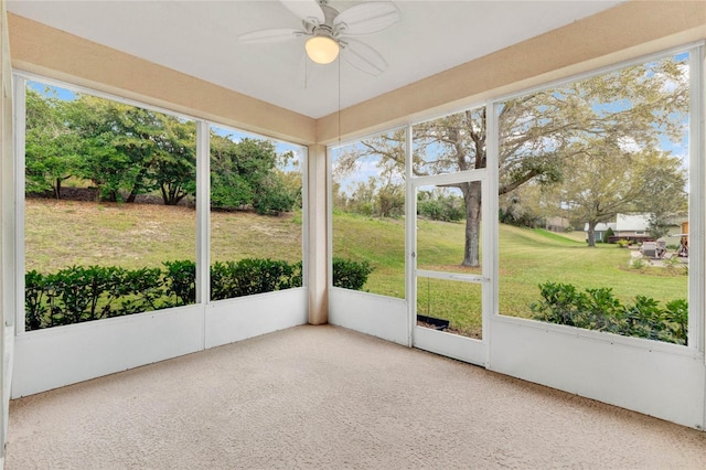 unfurnished sunroom featuring a ceiling fan