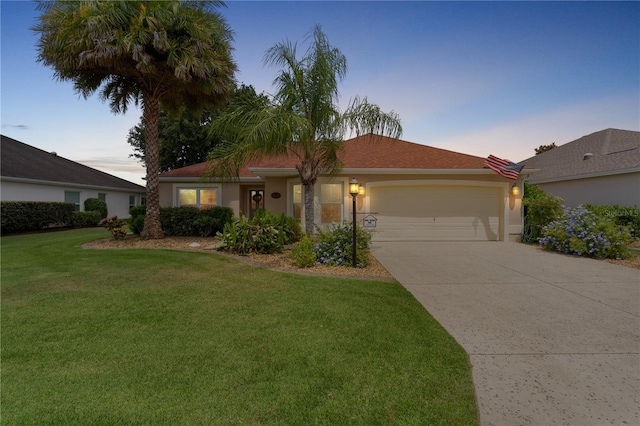 single story home with an attached garage, a lawn, driveway, and stucco siding