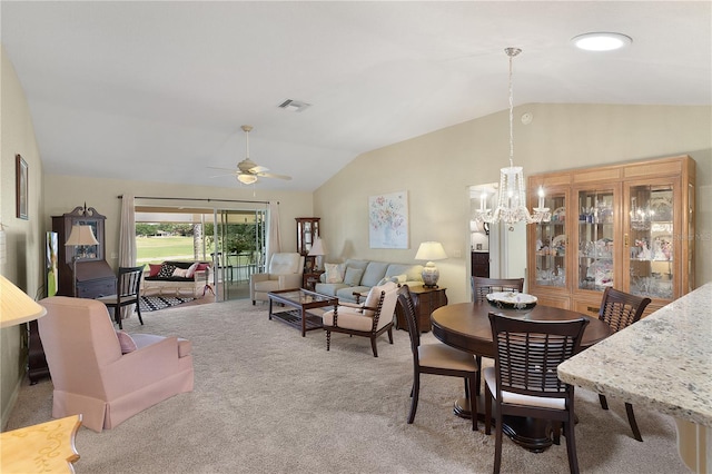 dining space with light carpet, visible vents, ceiling fan with notable chandelier, and vaulted ceiling