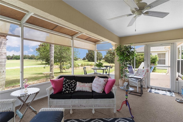 sunroom / solarium featuring a ceiling fan