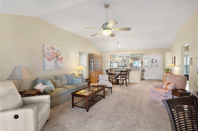 living room featuring vaulted ceiling, plenty of natural light, ceiling fan with notable chandelier, and light colored carpet