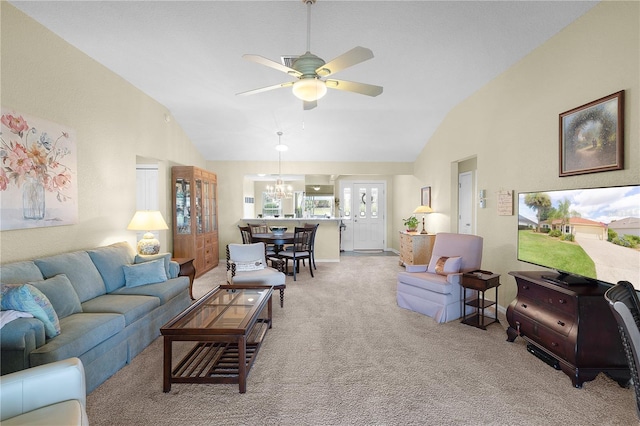 carpeted living area with high vaulted ceiling and ceiling fan with notable chandelier