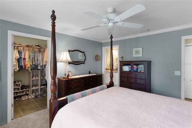 bedroom featuring a walk in closet, visible vents, a closet, and crown molding