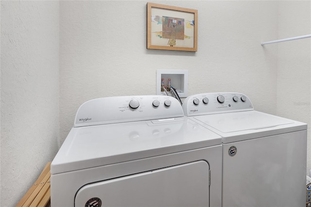 laundry area with washer and dryer, laundry area, and a textured wall