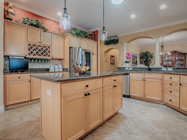 kitchen with a kitchen island, light brown cabinets, stainless steel appliances, and ornate columns