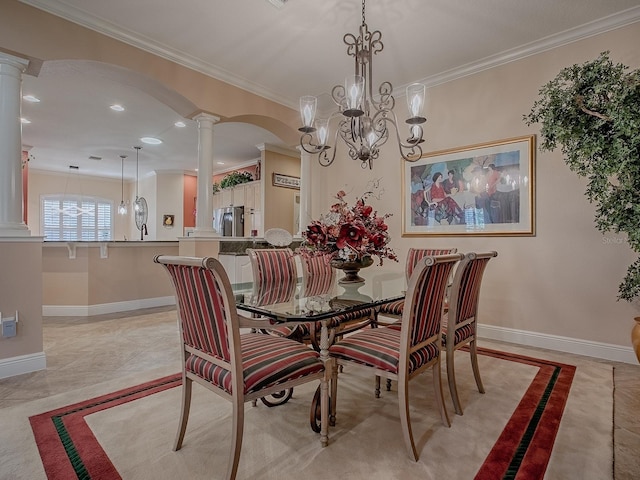 dining area with decorative columns, baseboards, and ornamental molding