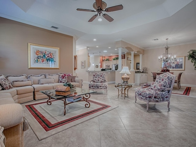 living room featuring visible vents, ceiling fan with notable chandelier, crown molding, decorative columns, and a raised ceiling