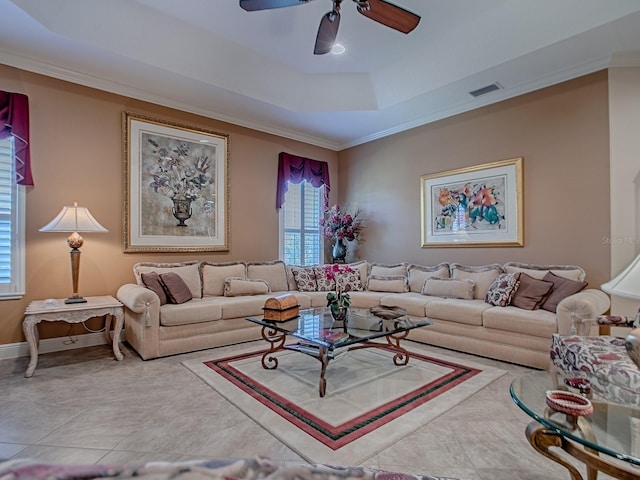 living room featuring a tray ceiling, baseboards, visible vents, and ceiling fan