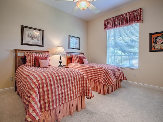 carpeted bedroom featuring multiple windows, baseboards, and ceiling fan