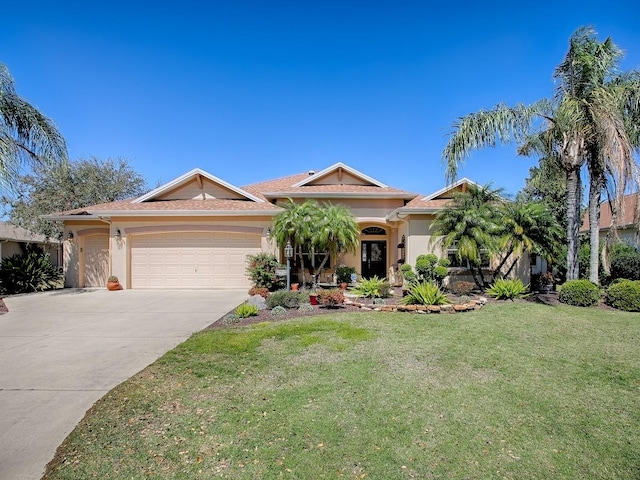 view of front of house with stucco siding, driveway, a front lawn, and an attached garage