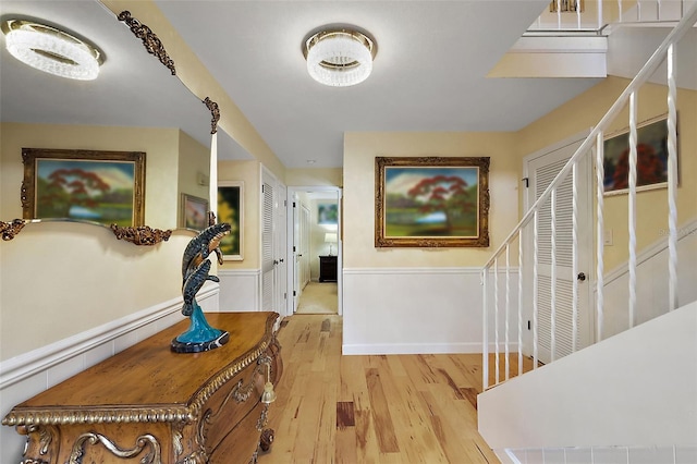 corridor featuring stairway, baseboards, and wood finished floors