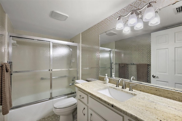 full bathroom featuring vanity, toilet, visible vents, and enclosed tub / shower combo