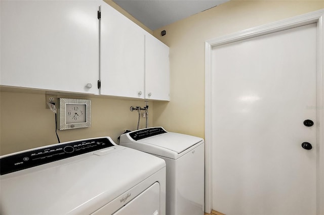 clothes washing area featuring cabinet space and independent washer and dryer