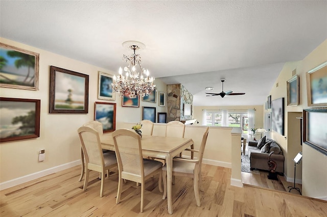 dining space with light wood-style flooring, ceiling fan with notable chandelier, and baseboards