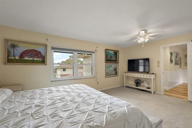 carpeted bedroom with a ceiling fan and baseboards