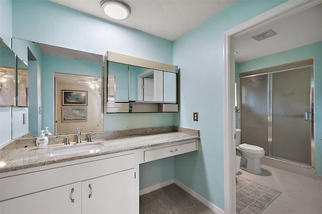 bathroom with visible vents, toilet, a stall shower, baseboards, and vanity