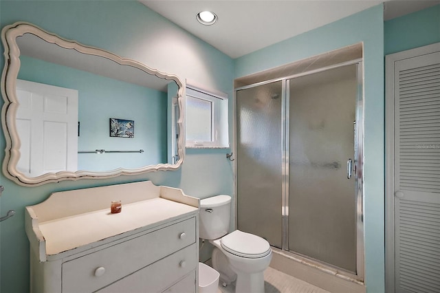 bathroom featuring vanity, toilet, a closet, and a stall shower