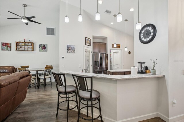 kitchen featuring dark wood-type flooring, open floor plan, stainless steel fridge with ice dispenser, and visible vents