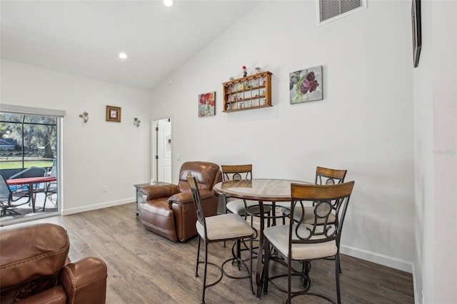 dining area featuring visible vents, wood finished floors, recessed lighting, baseboards, and vaulted ceiling