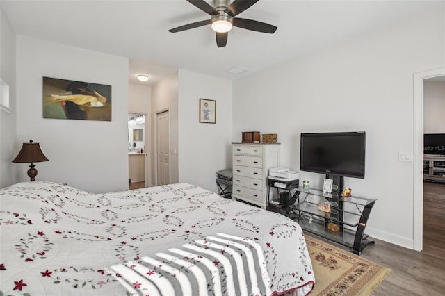 bedroom featuring ceiling fan, connected bathroom, baseboards, and wood finished floors