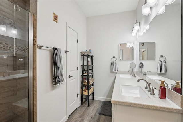 full bath with a shower stall, wood finished floors, and a sink