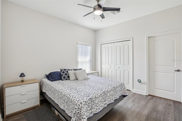 bedroom with dark wood finished floors, visible vents, a closet, and a ceiling fan