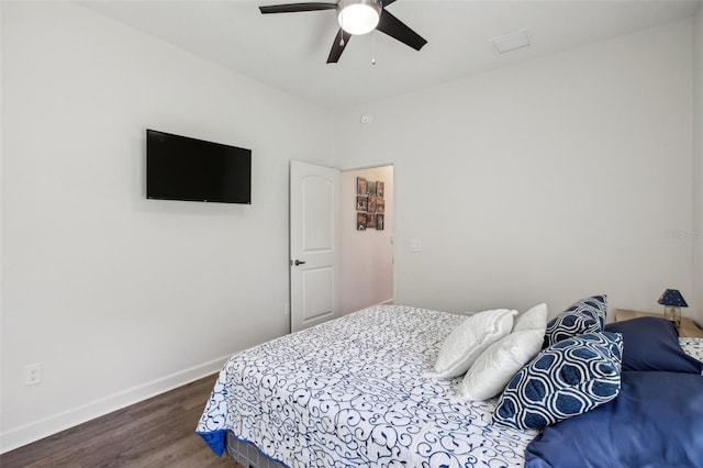 bedroom with a ceiling fan, wood finished floors, and baseboards