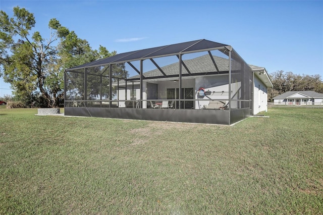 back of house featuring a lanai and a yard