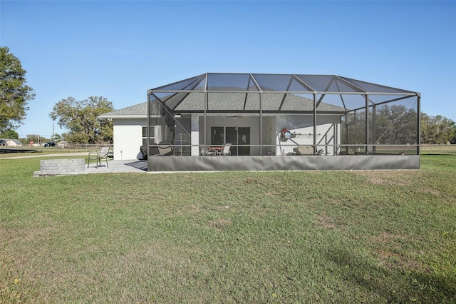 rear view of house featuring a patio area, a lawn, and a lanai