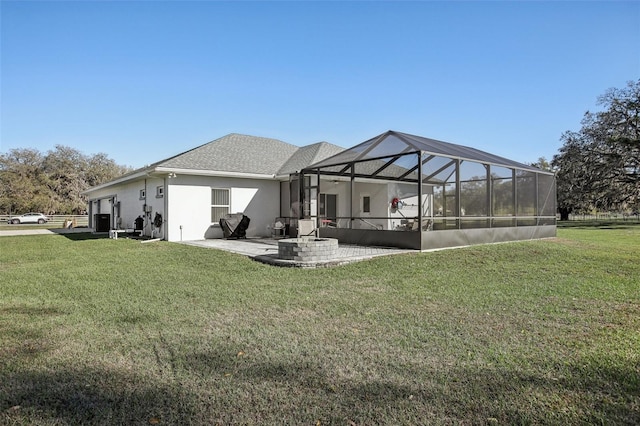 rear view of house with stucco siding, a patio, glass enclosure, a yard, and a garage