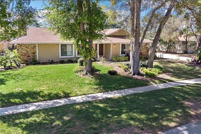 view of front of home with stone siding and a front yard