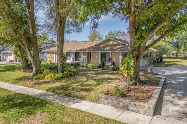 single story home featuring driveway, a front lawn, and a shingled roof