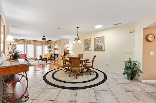 dining space with light tile patterned flooring, baseboards, visible vents, and ceiling fan