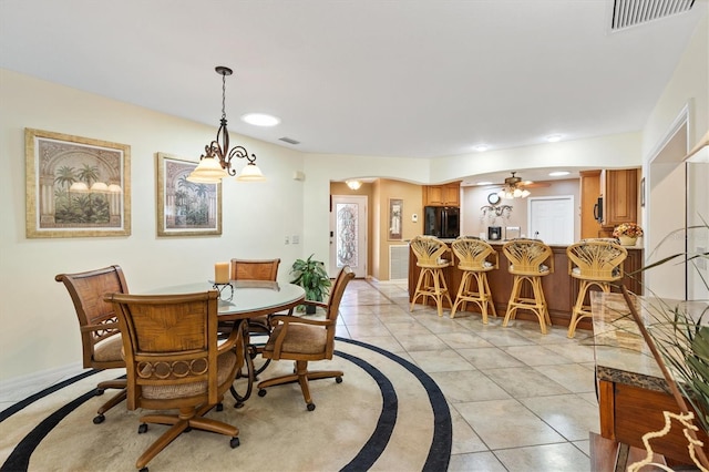 dining space with light tile patterned flooring, visible vents, arched walkways, and baseboards