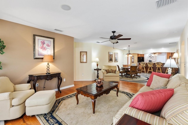 living area featuring visible vents, wood finished floors, and a ceiling fan