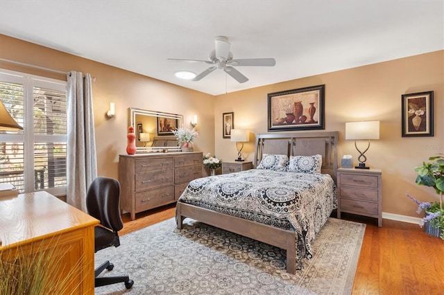 bedroom featuring ceiling fan, baseboards, and wood finished floors