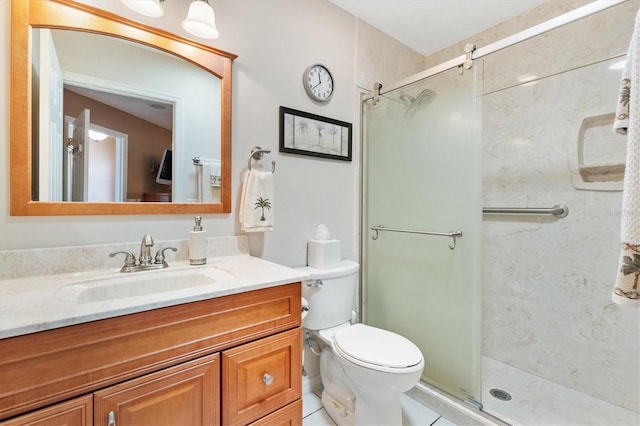 bathroom featuring tile patterned floors, toilet, a stall shower, and vanity