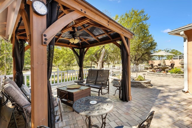 view of patio with a gazebo, ceiling fan, and fence