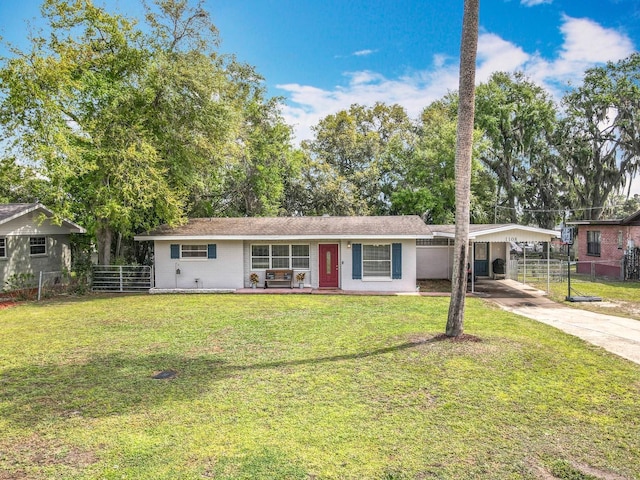 ranch-style home featuring a detached carport, concrete driveway, a front lawn, and fence