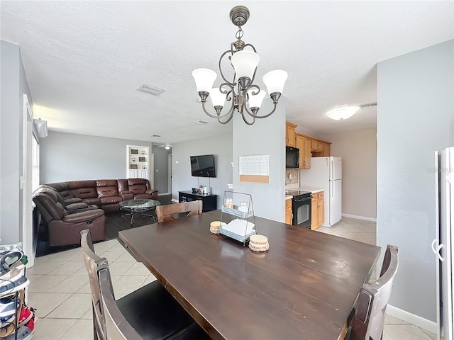 dining room featuring light tile patterned floors, visible vents, a textured ceiling, and an inviting chandelier