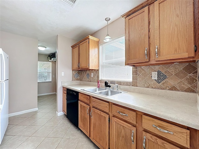 kitchen with black dishwasher, light tile patterned floors, decorative backsplash, freestanding refrigerator, and a sink