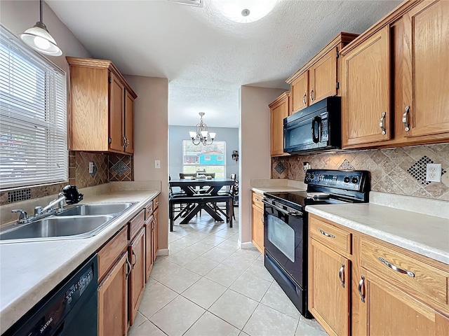 kitchen featuring light tile patterned floors, a sink, black appliances, light countertops, and pendant lighting