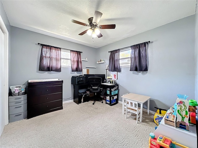 office featuring a wealth of natural light, a textured ceiling, a ceiling fan, and carpet